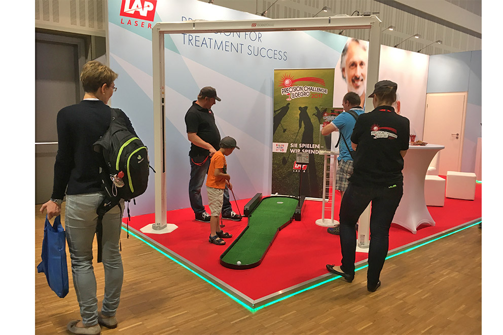 LAP booth at DEGRO 2017 a young kid playing mini golf for charity