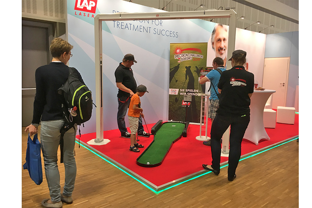 LAP Messestand DEGRO 2017, Kind spielt Minigolf für einen guten Zweck